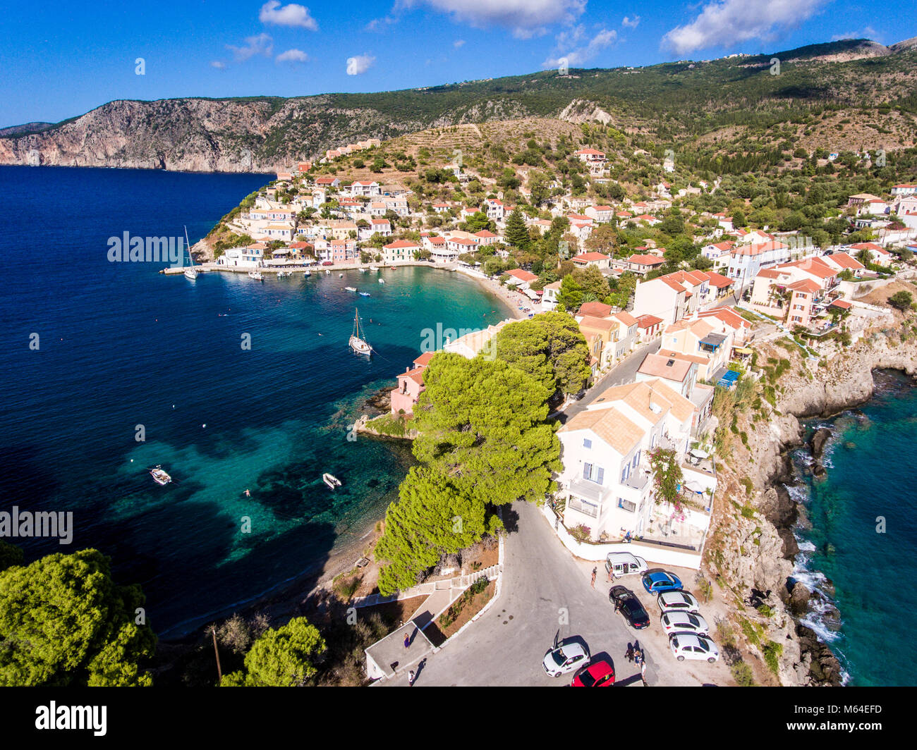 Luftaufnahme über Assos Kefalonia Strand mit klarem, blauen Wasser und Yachten im Hafen Stockfoto