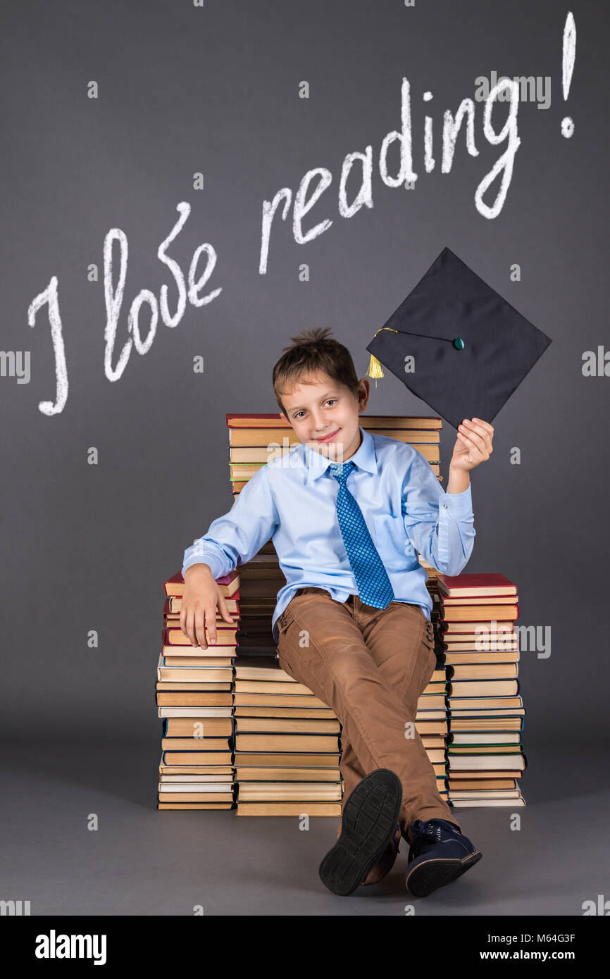 Bildung Konzept. Ein fröhlicher Junge, der gerne Bücher zu lesen Stockfoto
