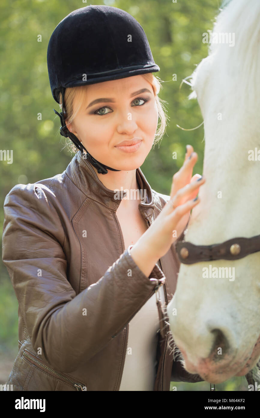Schöne Mädchen außerhalb streicheln Pferd Stockfoto