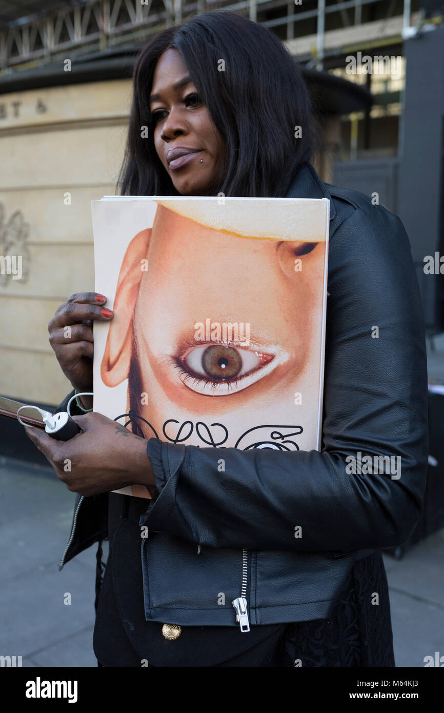 Kostenlose Zeitschriften mit Auge ist ein Modell, das auf dem Cover werden bereits am ersten Tag der London Fashion Week übergeben, am Strand, am 16. Februar 2018 in London, England, Stockfoto