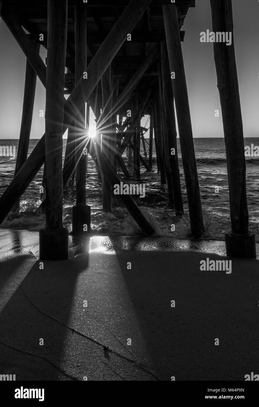 Sonnenstrahlen strahlen strahlen durch den Fischerpier auf Jersey Shore Stockfoto