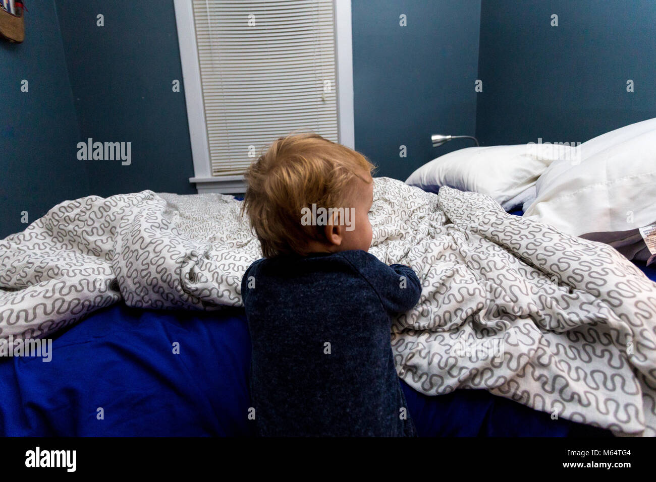 Wenig kaukasische Baby Kleinkind Junge, Tragen, Schlafanzüge, steigt in seinem Bett in seinem Suburban Schlafzimmer Stockfoto