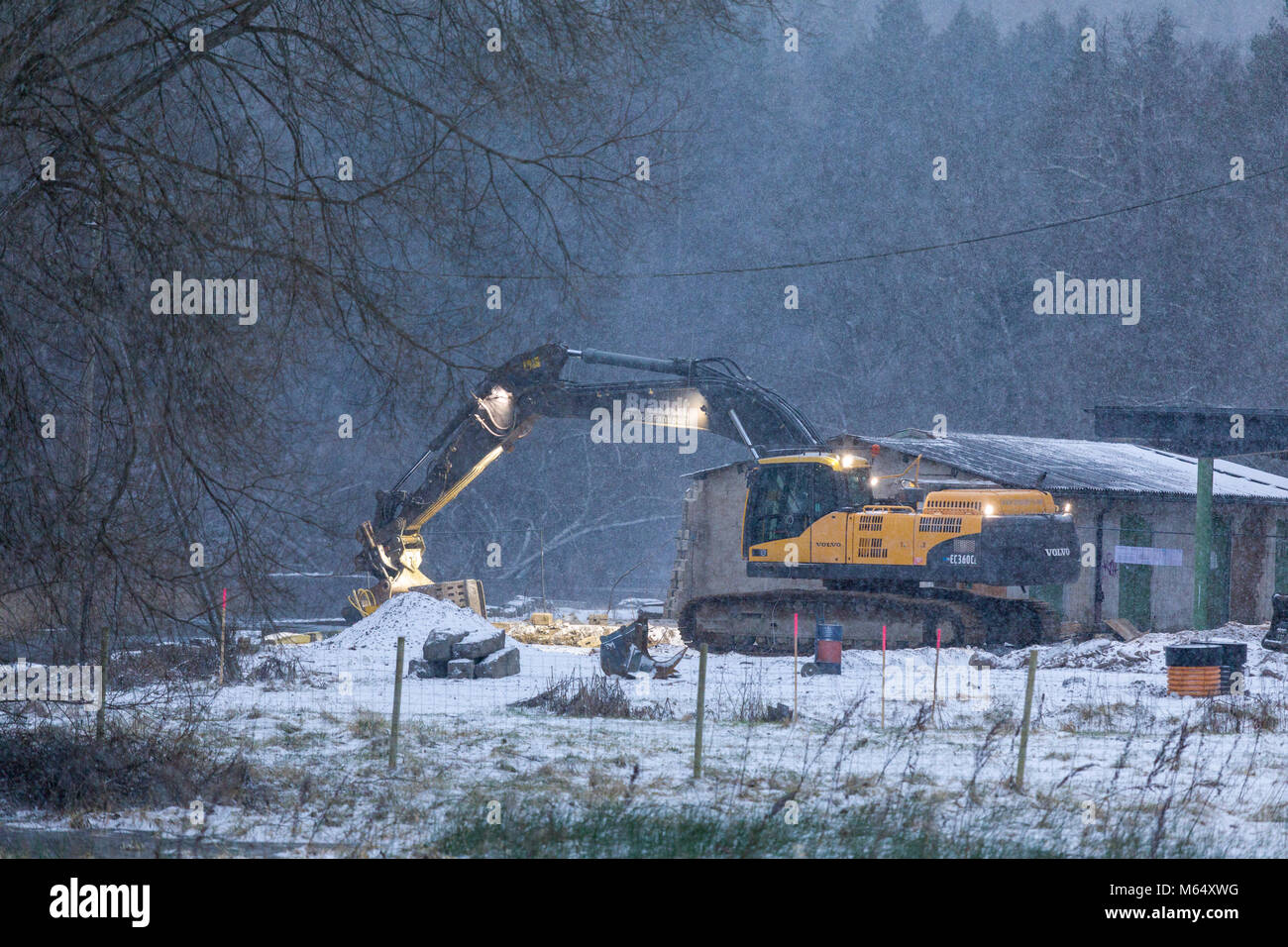 Auch, Schweden - 2. FEBRUAR 2018: Mobile artikuliert Bagger an der Baustelle arbeiten bei Schneefall im Winter Model Release: Nein Property Release: Nein. Stockfoto