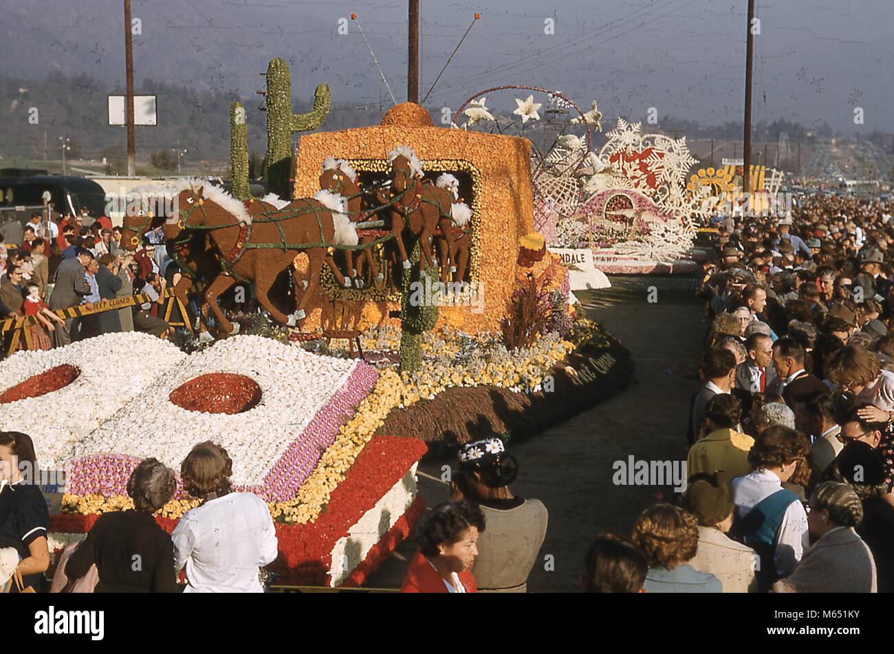 Ansicht der Massen bewundern die outdoor Exponate der Öffentlichkeit präsentieren nach dem Turnier 1956 von Roses Parade, in Pasadena, Kalifornien, 1956. In der Mitte ist die Post Getreide float mit dem Titel Ich Liebe eine Western, mit einem Team von blühenden Pferde galoppieren aus einem TV-Bildschirm. Die vordere Partie geformt wie ein offenes Buch, in dem sich Roy Rogers und Dale Evans während der Parade Prozession saß. () Stockfoto