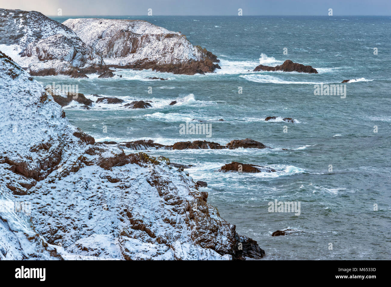 Küste von Moray in Schottland in der Nähe von PORTKNOCKIE IM FEBRUAR WINTER Sturm mit starkem Wind und Schnee bedeckten Klippen Stockfoto