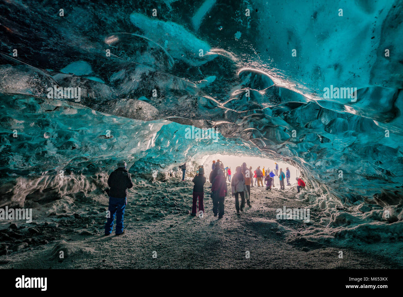 Touristen, die sich in der Crystal Cave, Breidamerkurjokull Gletscher, Island. Emerald Blue Ice und Asche ist Teil der Breidamerkurjokull. Stockfoto