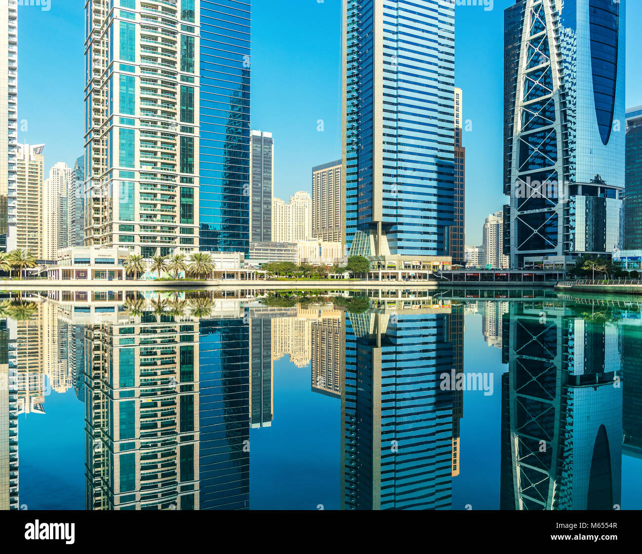 31.Dezember 2017 - Dubai, UAE. Die Jumeirah Lakes Towers reflektieren, die noch Wasser. Stockfoto