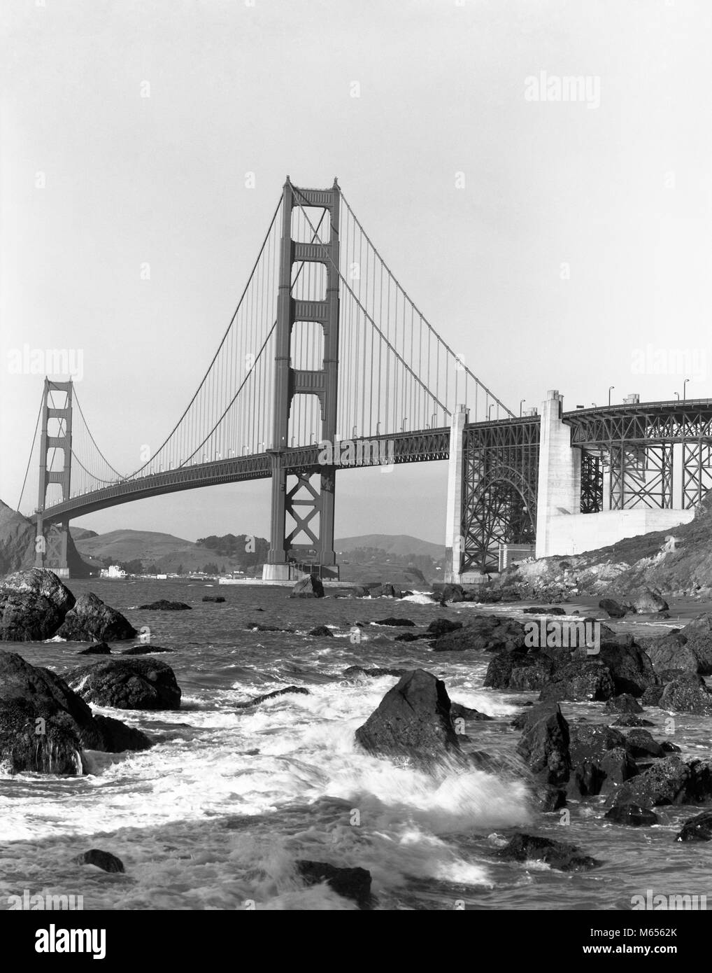 1960er Jahre GOLDEN GATE BRIDGE SAN FRANCISCO CA USA ERÖFFNET FÜR DEN VERKEHR 1937-b 3373 FST001 HARS 1937 B&W SCHWARZ UND WEISS BRÜCKEN GOLDEN GATE WAHRZEICHEN ALTMODISCHE felsigen Ufer STRAIT SUSPENSION WUNDER DER MODERNEN WELT Stockfoto