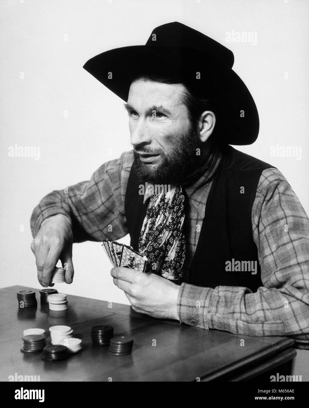1930er Jahre bärtiger Mann Cowboy spielen Wetten Wetten poker chips - c 988 HAR 001 HARS WAHL AUFREGUNG LUCKY FREIZEIT GELEGENHEIT SPIELEN MÄNNER B&W WETTE WETTEN SCHWARZ UND WEISS KAUKASISCHEN ETHNIE CHANCE COWBOYHUT SPIELER SPIEL DES ZUFALLS ALTMODISCHE PERSONEN POKE Stockfoto