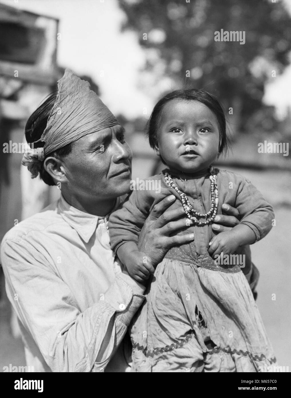 1930er Jahre stolze INDIANER NAVAJO MANN VATER HOLDING BABY MÄDCHEN TOCHTER SUCHEN BEI KAMERA-i 1138 HAR 001 HARS FREUDE LIFESTYLE FRAUEN STOLZ LÄNDLICHEN GESUNDHEIT LEBEN ZU HAUSE KOPIEREN RAUM MIT HALBER LÄNGE TÖCHTER INDIANER NAVAJO AMERICANA FAMILIEN NOSTALGIE VÄTER NORDAMERIKA ZWEISAMKEIT AUGENKONTAKT 20-25 Jahre 25-30 JAHRE NORDAMERIKANISCHEN VATERSCHAFT GLÜCK FRÖHLICHE VATIS STOLZ WACHSTUM LÄCHELT FRÖHLICH NATIVE AMERICAN 6-12 MONATE JUNGEN MÄNNER Mitte - Mitte - erwachsenen Mann junger Erwachsener MAN B&W BABY GIRL SCHWARZ UND WEISS INDIGENEN AUF KAMERA ALTMODISCHE PERSONEN Stockfoto