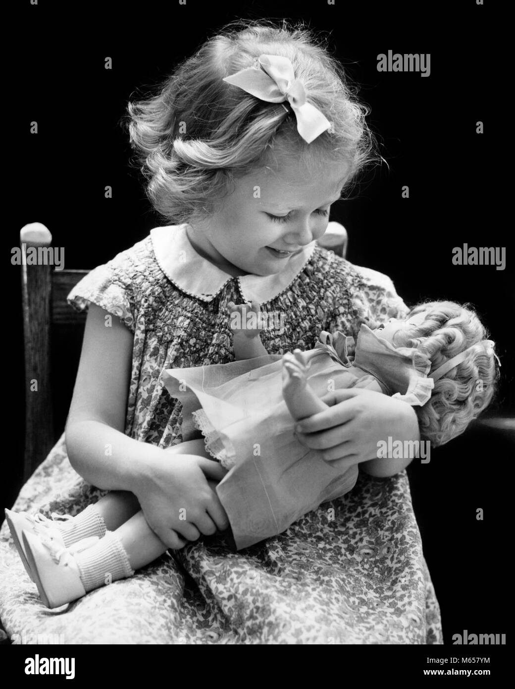 1930er Jahre 1940er Jahre lächelnde blonde Mädchen HOLDING BABY DOLL - j1513 HAR 001 HARS GESUNDHEIT NUR EINE PERSON LEBEN ZU HAUSE KOPIEREN RAUM FREUNDSCHAFT halber Länge PFLEGE ZUHAUSE VERTRAUEN NOSTALGIE ZWEISAMKEIT 1-2 JAHRE 3-4 JAHRE einzelnes Objekt GLÜCK ABENTEUER SCHUTZ ANSCHLUSS FANTASIE BABY DOLL JUGENDLICHE B&W BABY GIRL SCHWARZ UND WEISS KAUKASISCHEN ETHNIE DOLLY ALTMODISCHE SMOCKING Stockfoto