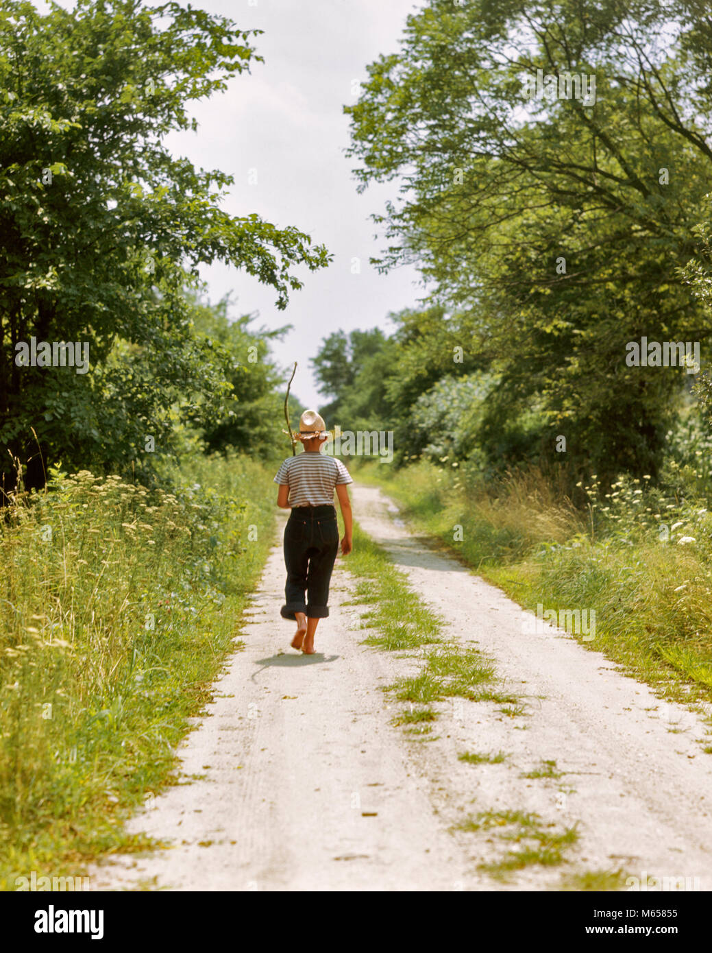 1940er Jahre 1950er Jahre barfüssigen Jungen HINUNTER COUNTRY LANE IM SOMMER MIT EINEM ZWEIG ANGELRUTE auf seiner Schulter-ka 2 HAR 001 HARS BARFUSS STROHHUT FLUCHT JUNGEN MÄNNER vor - jugendlich vor - jugendlich Jungen KAUKASISCHEN ETHNIE LAND WEG GEGANGEN ANGELN ALTMODISCHEN ZWEIG Stockfoto