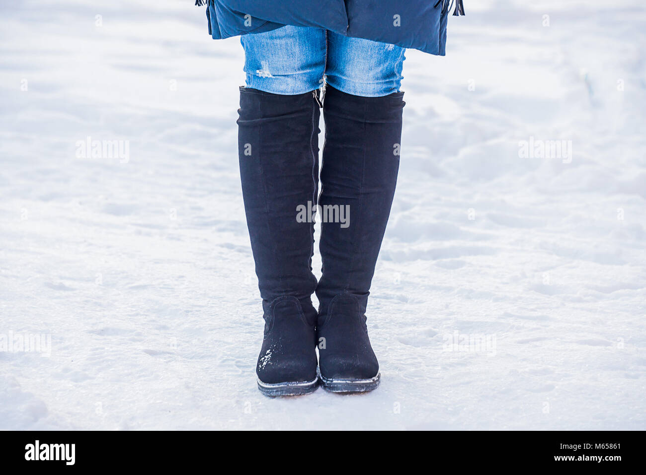 Frauen Füße in Stiefeln, im Winter im Schnee, Kälte krumme Füße, winter Schuhe, die Prüfung der Festigkeit, Warten auf ein Datum Stockfoto