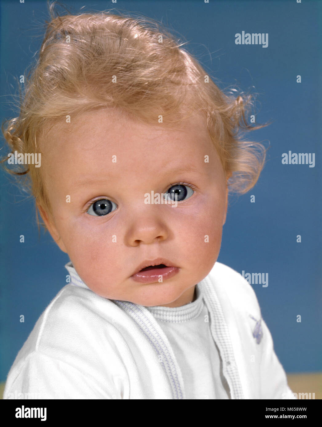 1970 s PORTRAIT WINSOME LOCKIGE blonde Haare blaue Augen BABY SUCHEN BEI CAMERA-kb3814 HAR 001 HARS JUGENDLICHE BABY BLUES BLUE EYED BLUE EYES KAUKASISCHEN ETHNIE AUF KAMERA ALTMODISCHE WINSOME Stockfoto