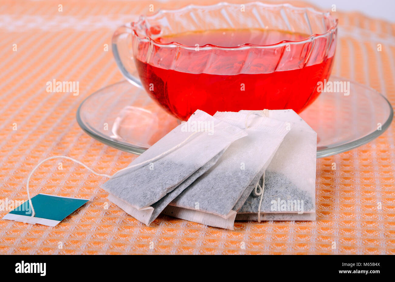 Transparentes Glas Teetasse mit Tee und drei Teebeutel gefüllt Stockfoto