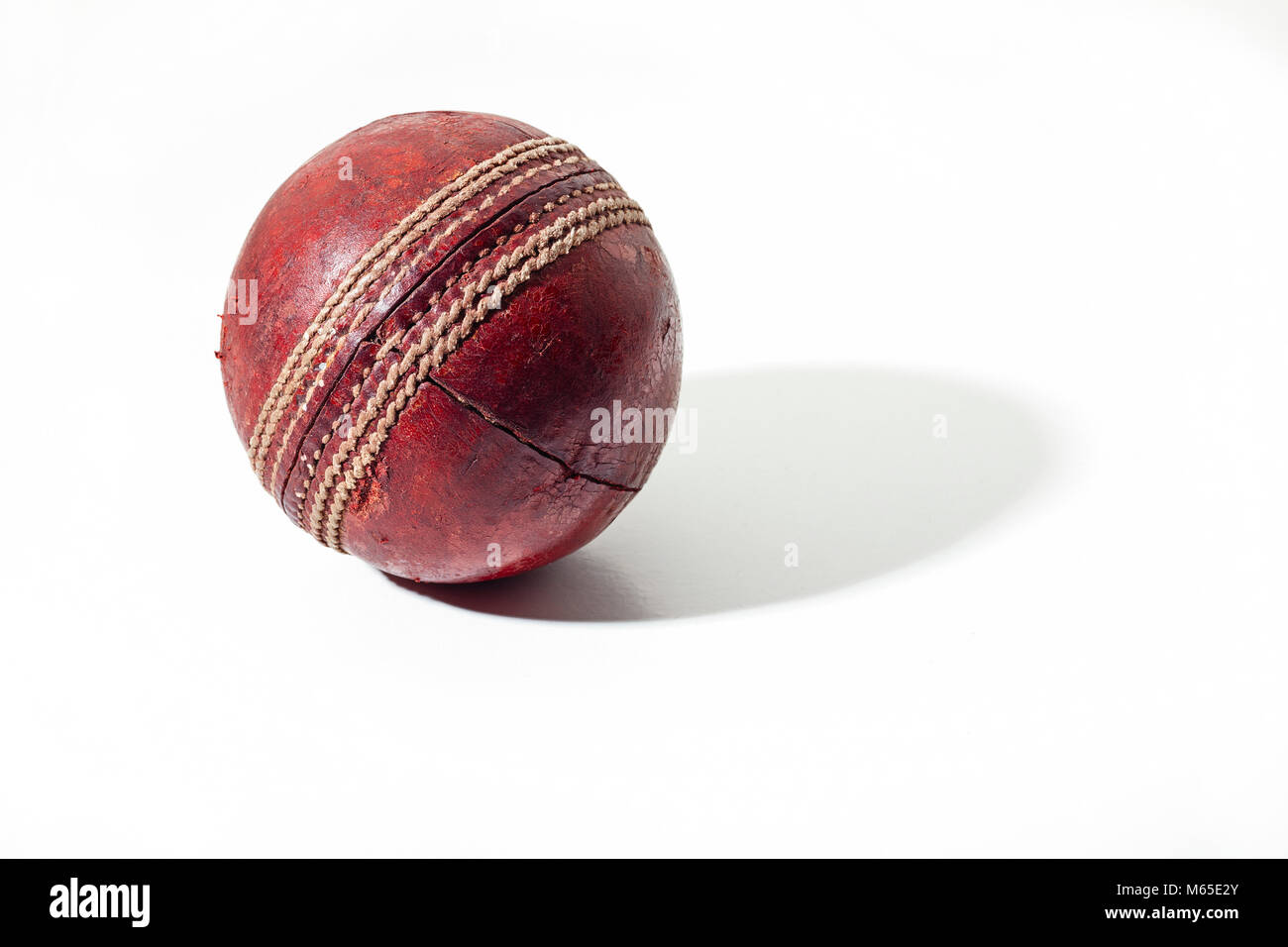 Dunkelrot ältere Cricket Ball auf weißem Hintergrund Stockfoto