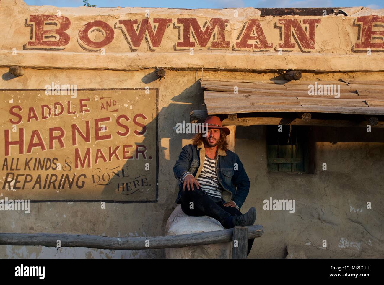 Im westlichen Stil Mann vor einem Glauben Sattlerei Store bei Texas Hollywood, Almeria Spanien Stockfoto