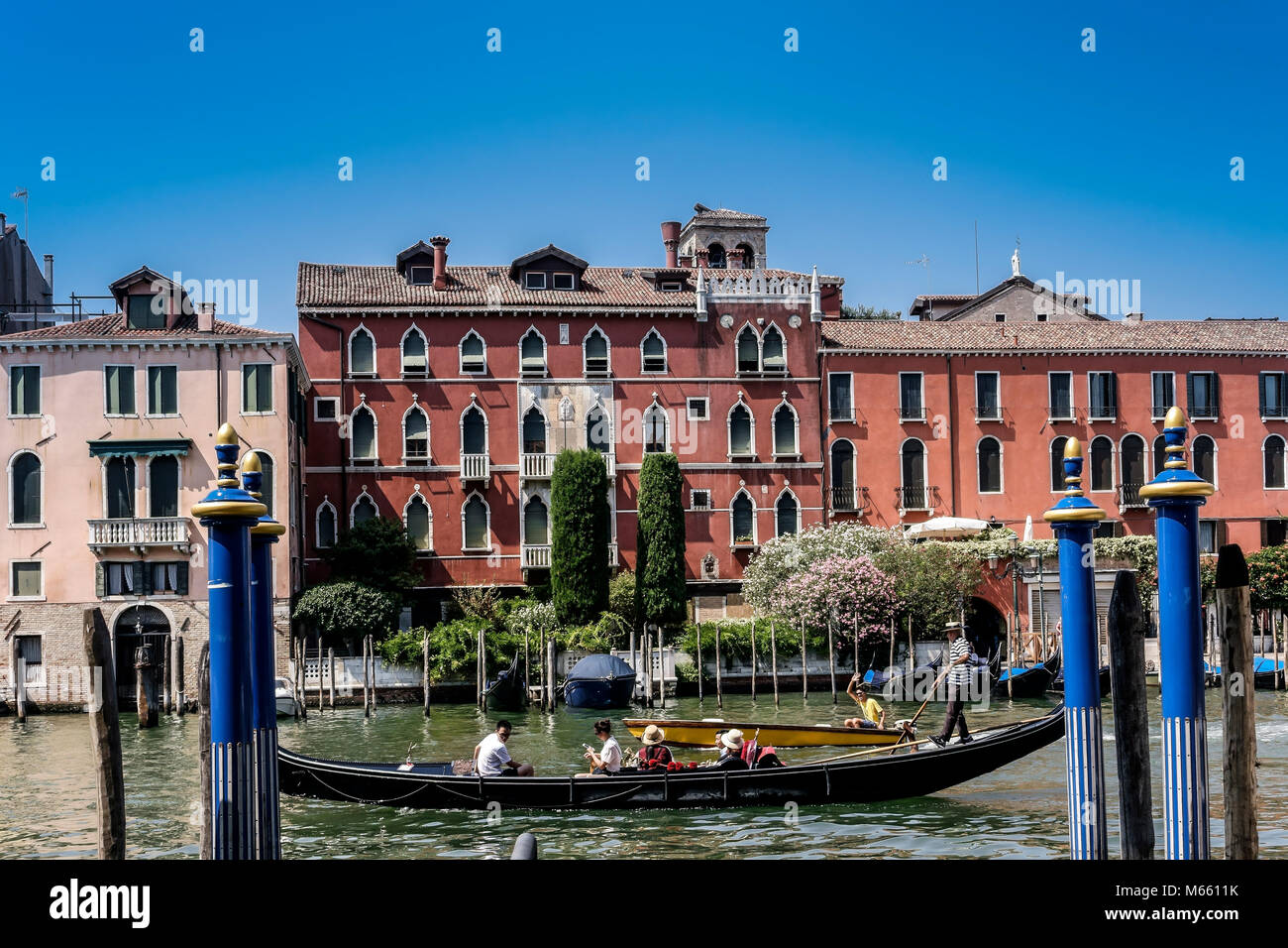 Gondolier mit Gondel, mit Touristen zu einer Stadtrundfahrt durch den Canal Grande. Zauberhaftes Venedig, Italien, Europa, EU. Blauer Himmel, Kopierbereich. Stockfoto