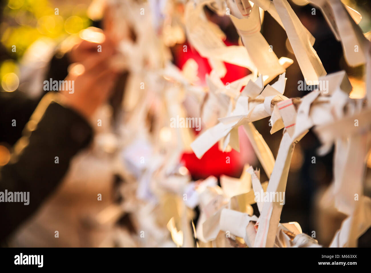 Nahaufnahme Gruppe von Omikuji, Wahrsagen Papierstreifen, auf den Seilen mit unscharfen Hintergrund gebunden. Die Menschen glauben, dass Sie Pech omen om Stockfoto