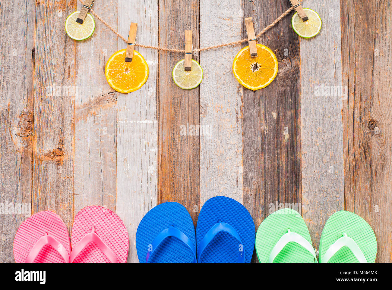 Pink, Blau und Grün flip flop Sandalen auf Holz Hintergrund. Zitrusfrüchte. Stockfoto