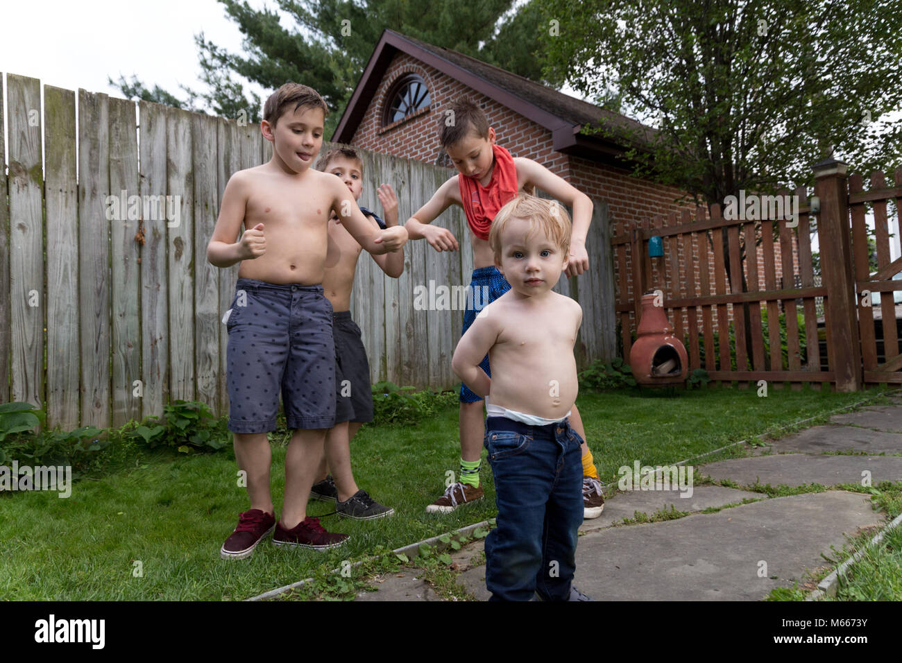Vier kaukasischen Jungen spielen Mit sprizen Gewehren und Einander bei einem warmen Sommertag Stockfoto