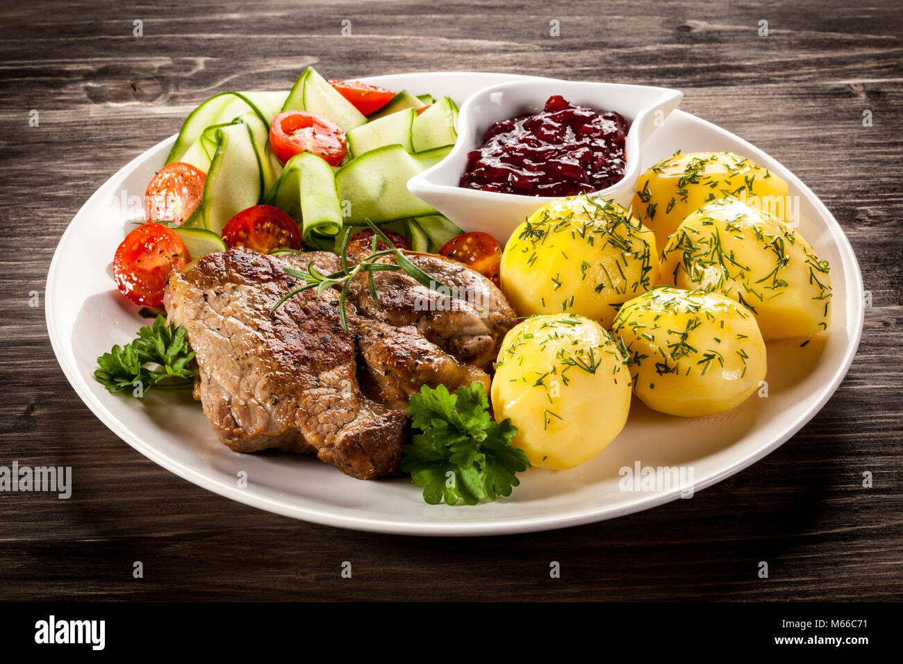 Ried Steak, gekochte Kartoffeln und Gemüse Salat auf hölzernen Tisch  Stockfotografie - Alamy