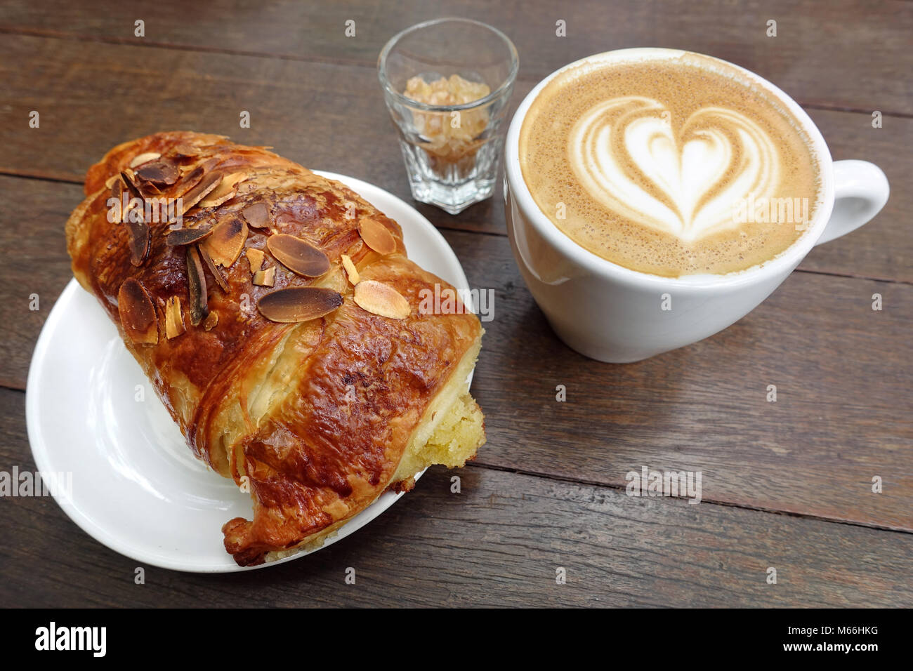 Perfektes Frühstück Kombination: Tasse Cappuccino und frisch gebackene almond Croissants. Stockfoto