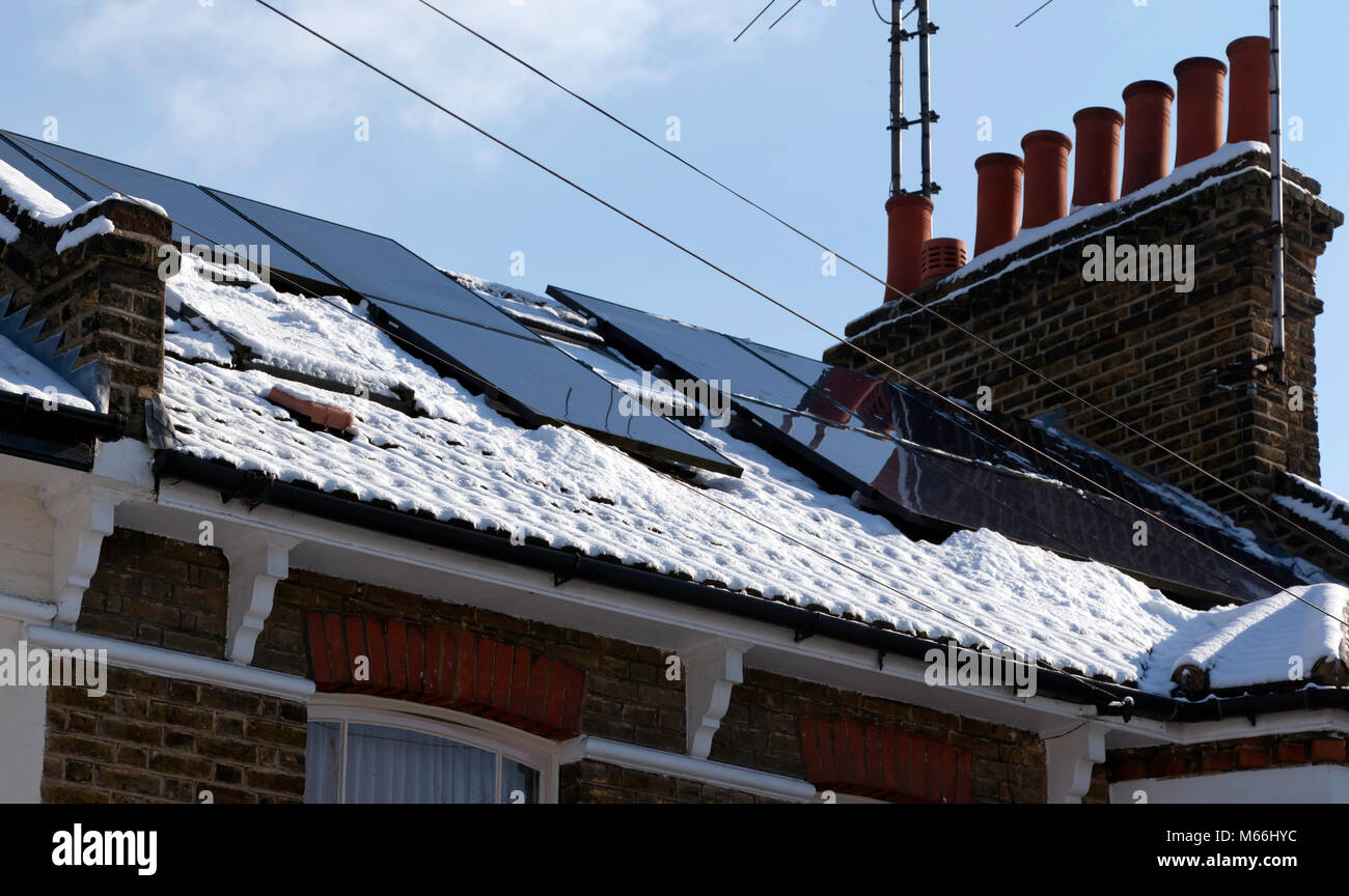 Schnee ist von 10 Photovoltaik Solarzellen auf dem Dach eines Hauses in Lewisham gelöscht Stockfoto