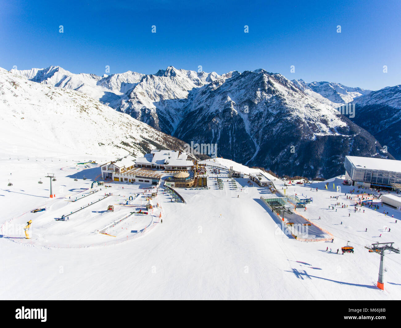 Panoramablick auf das Luftbild von Skigebiet in den Alpen mit Skilift und Menschen Skifahren auf der Piste Stockfoto