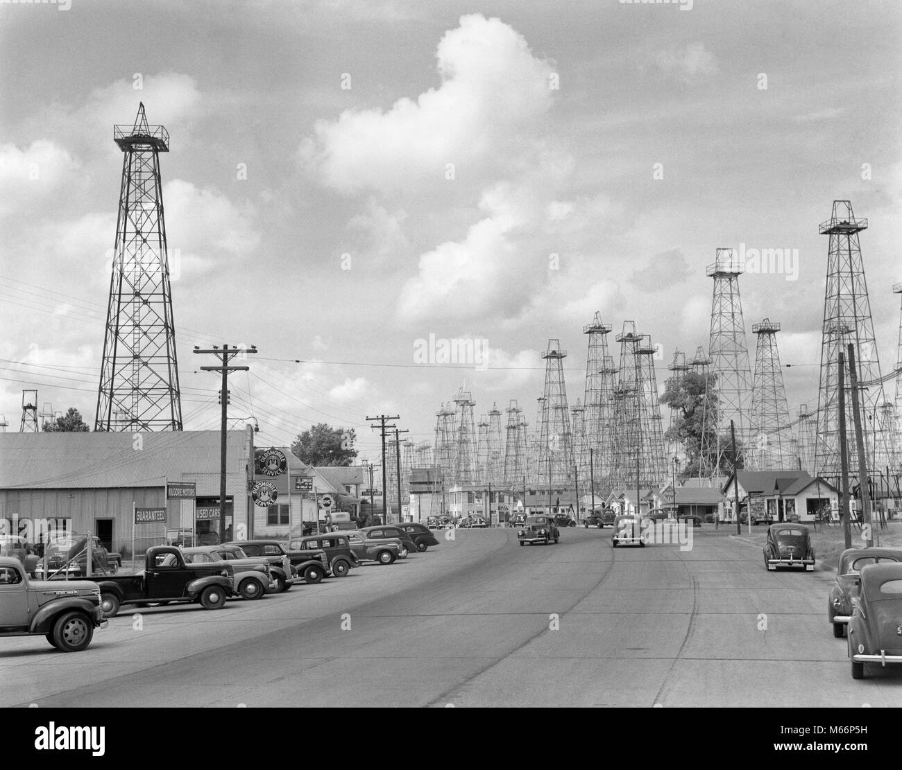 1940 s Highway durch Wald von ÖLDERRICKKRÄNE KILGORE TEXAS USA-q 41356 CPC 001 HARS RIG RIGS Stockfoto