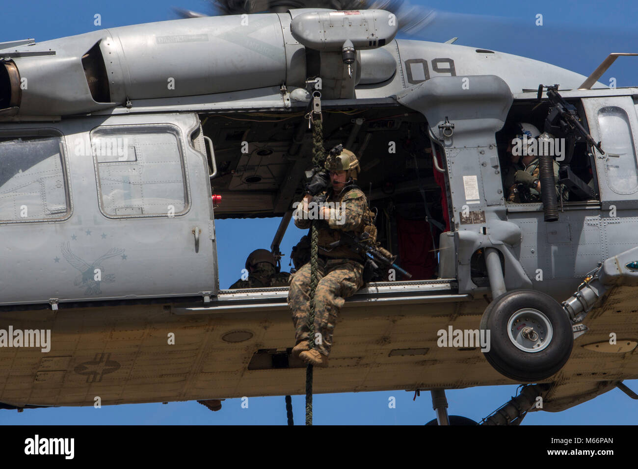 Ein Force Reconnaissance Marine mit maritimen Raid-Kraft, 31 Marine Expeditionary Unit, schnelle Seile aus einem MH-60S Seahawk in Guam, 23. Januar 2018, während des Besuchs Board Durchsuchung und Beschlagnahme Training. VBSS lehrt Marines wie über Schiffe für die Suche und die Bekämpfung der Piraterie. Wie das Marine Corps' nur kontinuierlich vorwärts - bereitgestellt MEU, den 31 MEU bietet eine flexible Kraft bereit, eine breite Palette von militärischen Operationen auszuführen. (U.S. Marine Corps Foto von Cpl. Bernadette Wildes) Stockfoto