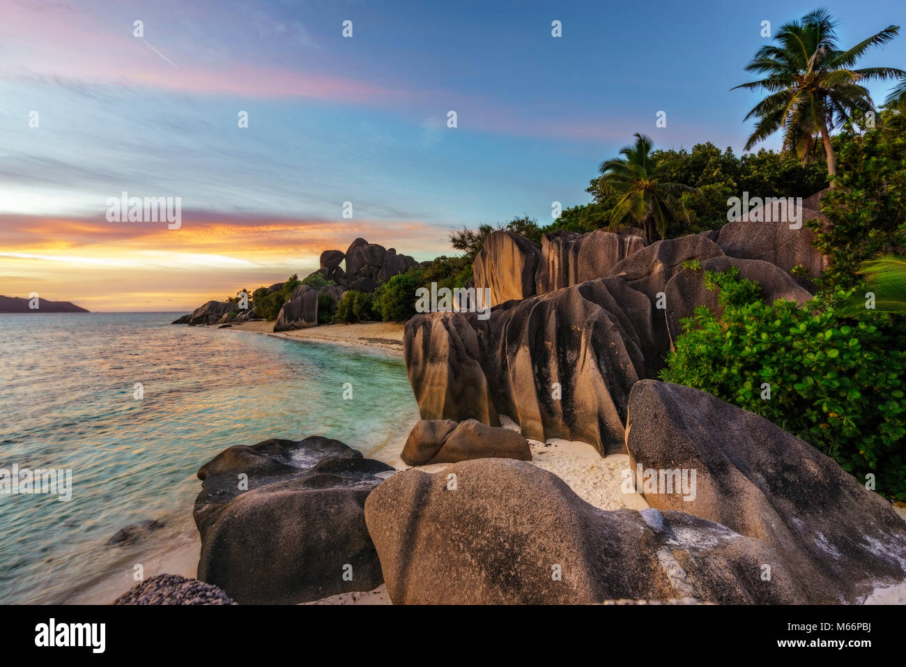 Schönen Sonnenuntergang zu erstaunlichen malerischen Paradise Beach. Granitfelsen, weißer Sand, Palmen, türkisfarbenes Wasser am tropischen Strand Anse Source D'Argent, La Stockfoto