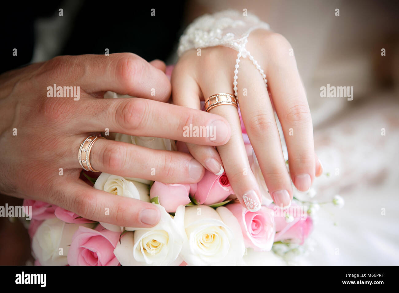 Hände der Bräutigam und die Braut mit Hochzeit Ringe und eine Hochzeit Blumenstrauß aus Rosen Stockfoto