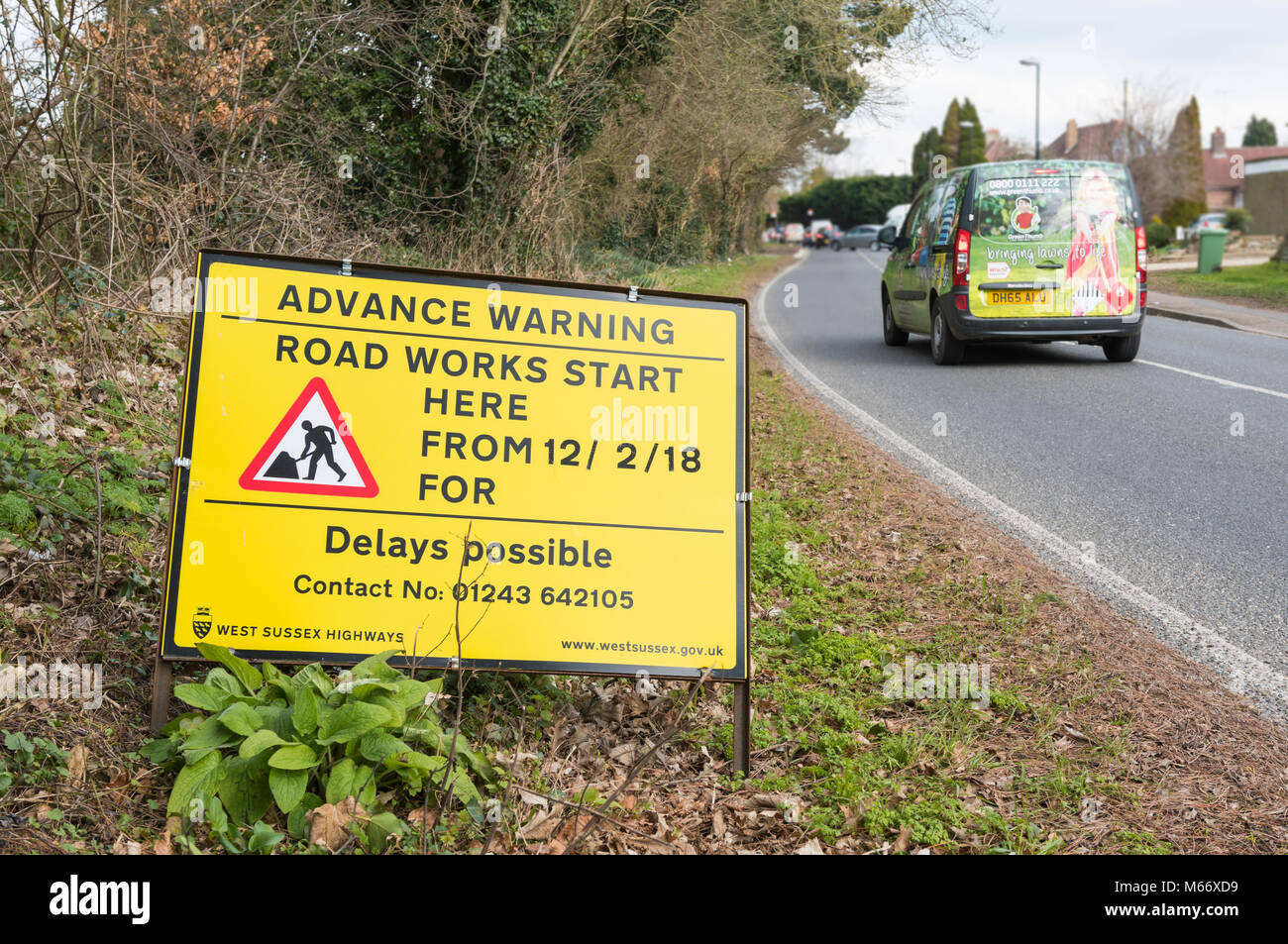 Gelb Vorwarnung am Straßenrand Zeichen von Verzögerungen durch Bauarbeiten starten in Angmering, West Sussex, England, UK zu warnen. Stockfoto