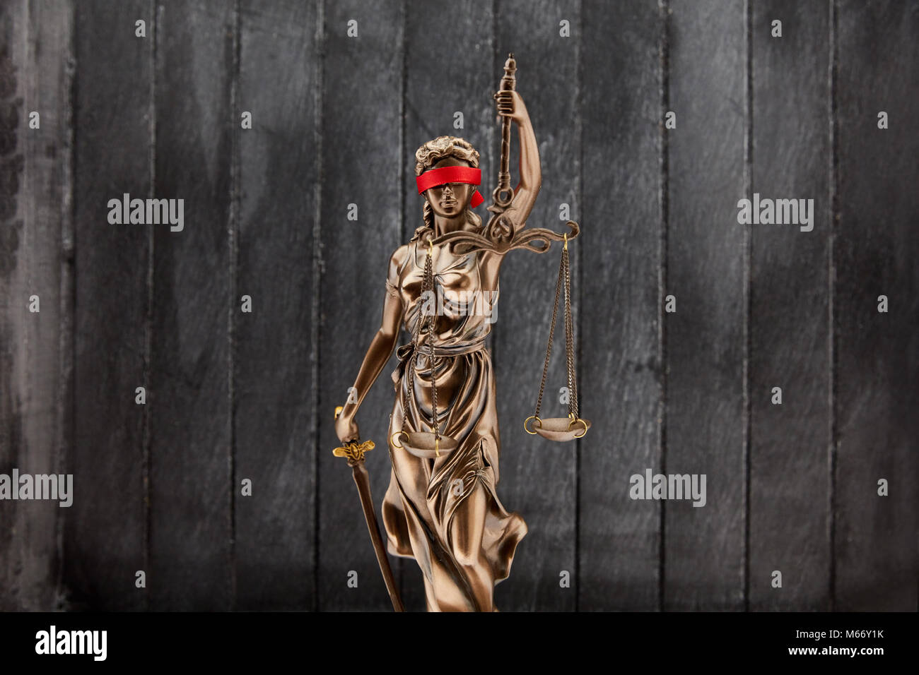 Justitia mit Augenbinde vor Holz Hintergrund als Gerechtigkeit Konzept Stockfoto