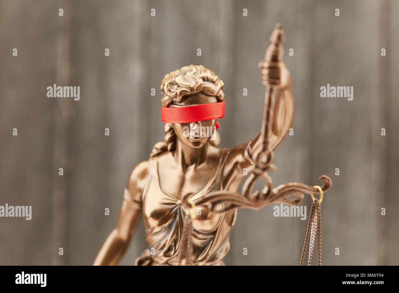 Justitia mit Augenbinde als Gerechtigkeit Konzept vor einem Holz Hintergrund Stockfoto