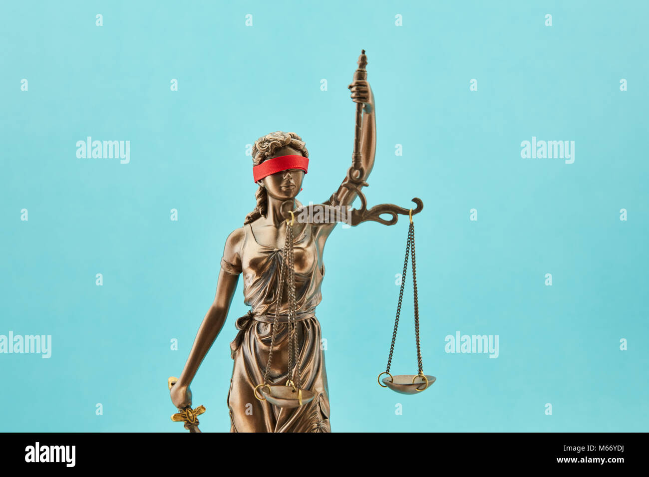Justitia mit Augenbinde als Gerechtigkeit Konzept vor einem blauen Hintergrund Stockfoto