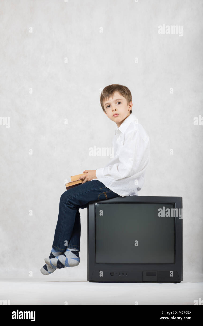 Junge von sieben Jahre alt und ein alter Fernseher. Freier Speicherplatz für einen Text. Stockfoto