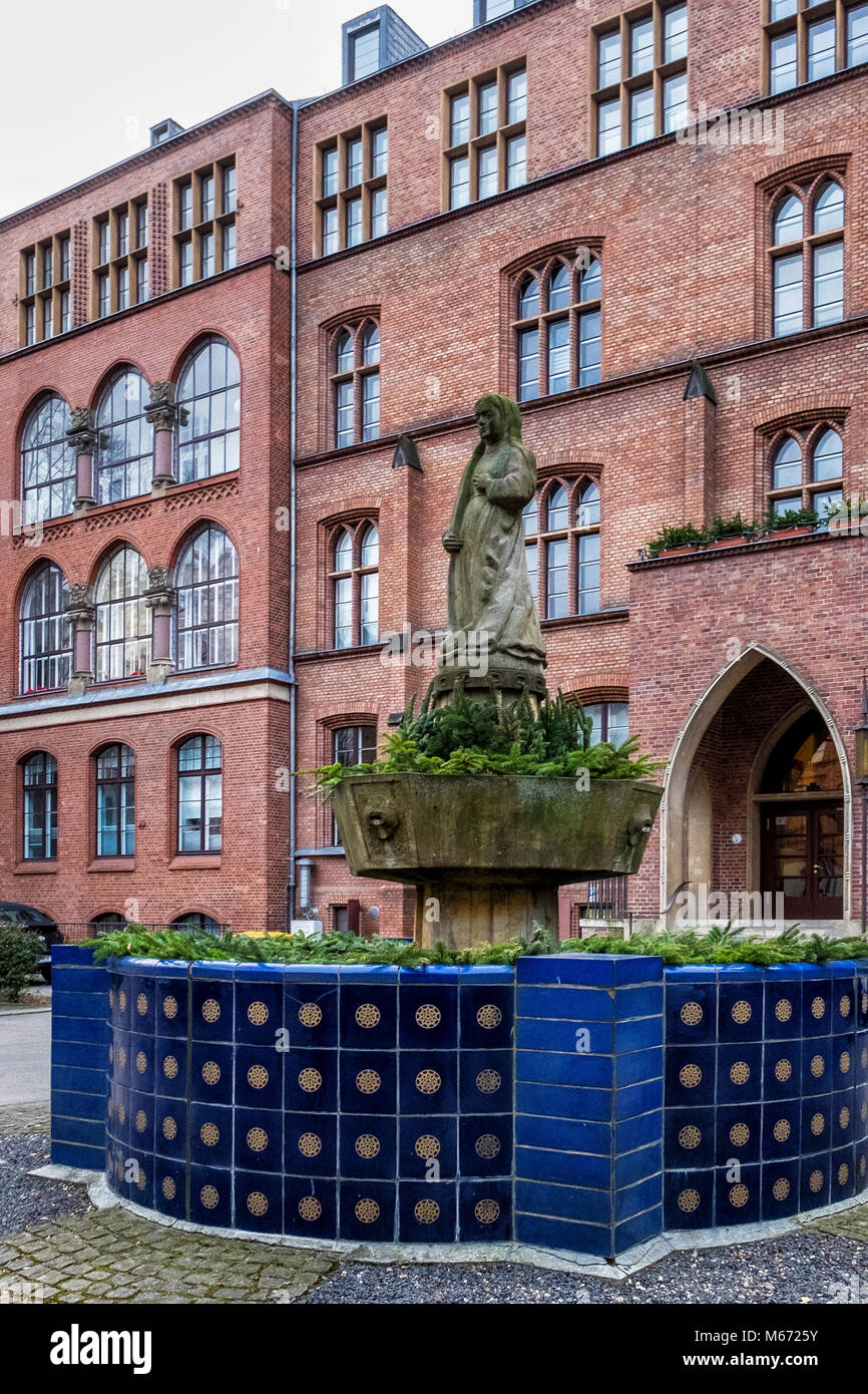 Berlin, Mitte, St. Hedwigs Krankenhaus, Haupthaus, neugotische Gebäude aus rotem Backstein außen & Fassade mit Skulpturen & Hl. Agatha Brunnen der Cl Stockfoto