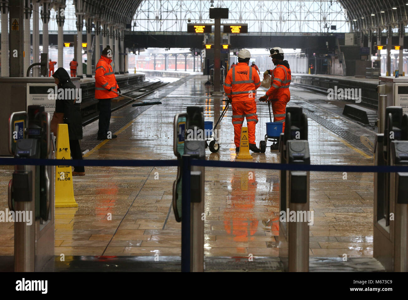 Network Rail Arbeitnehmer mop bis Wasser auf geschlossenen Plattformen am Paddington Bahnhof in London, als Sturm Emma, Rolling vom Atlantik, sieht balanciert, das Tier aus dem Osten kühl Russland Luft zu begegnen - weiter verbreitet Schneefall und bitteren Temperaturen. Stockfoto