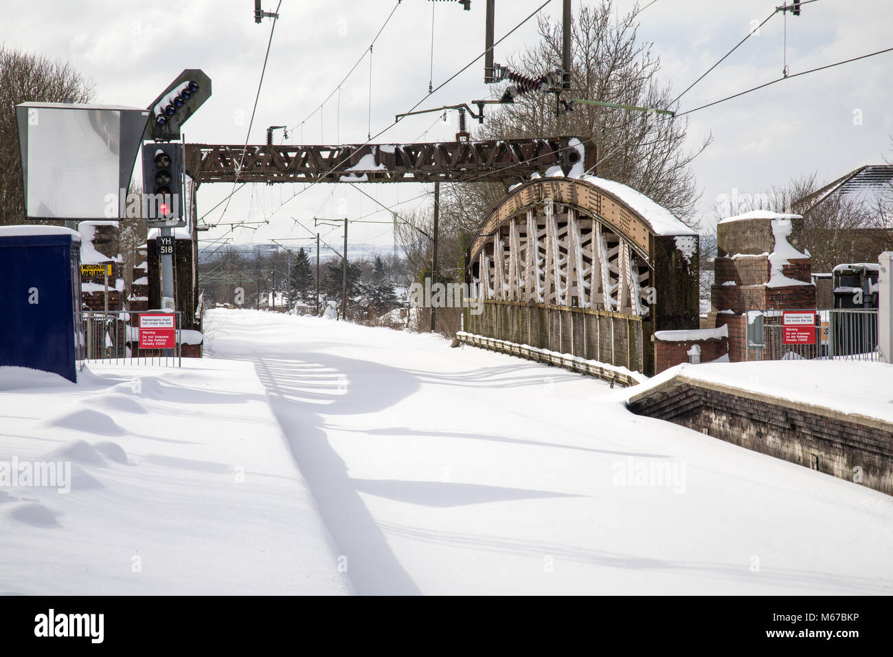 Glasgow, Schottland, Großbritannien. 1. März, 2018. ​The rot Wetterwarnung für Zentrale Schottland hat bestanden, aber der starke Schneefall hat der Stadt Glasgow zu einer fast zum Stillstand gebracht. Viele Unternehmen sind aufgrund der Wetter geschlossen. Öffentliche Verkehrsmittel Mit der Bahn und Bus sind ausgesetzt. Zug Services werden über viel von Central Scotland ausgesetzt. Auf den meisten Stationen die Bahngleise sind mit Schnee bedeckt. Hier sehen Anniesland station in Glasgow West. © Garry Cornes/Alamy leben Nachrichten Stockfoto