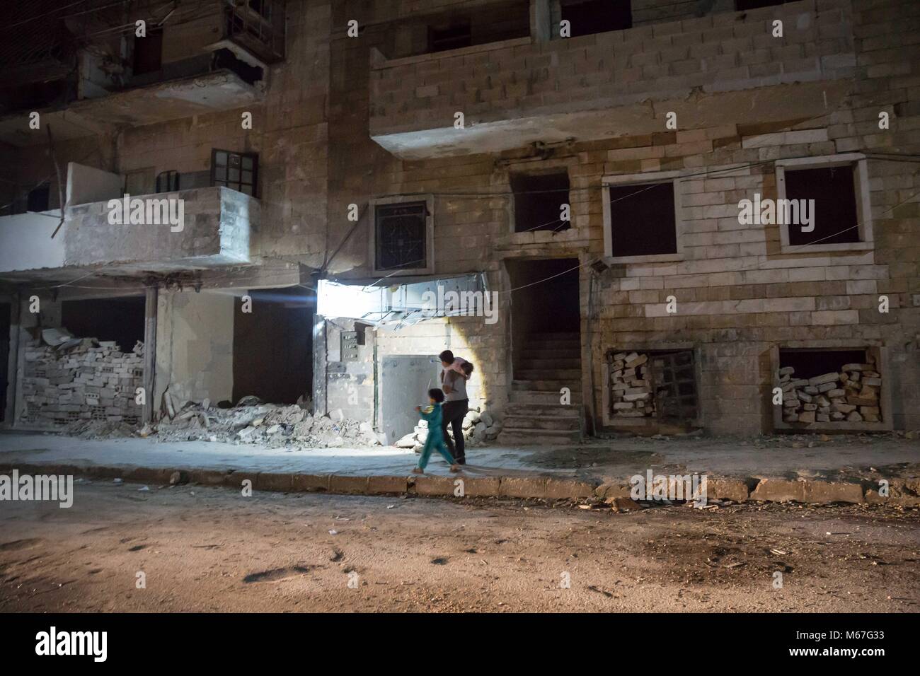 Aleppo, Syrien. 1 Nov, 2017. Ein Junge verwendet eine Fackel durch Schutt in der dezimiert Ansari al Sharki, die seit Jahren durch die Truppen der Rebellen gehalten wurde. Die größte Stadt Aleppo in Syrien mit Bevölkerung über 4,5 Mio. eingesetzt, bevor der Krieg im Jahr 2012 brach zu suchen. Der östliche Teil der Stadt wurden von anti Assad Rebellen von 2012 bis Ende 2016. Credit: S Hayden 010318 3.jpg SOPA/Images/ZUMA Draht/Alamy leben Nachrichten Stockfoto