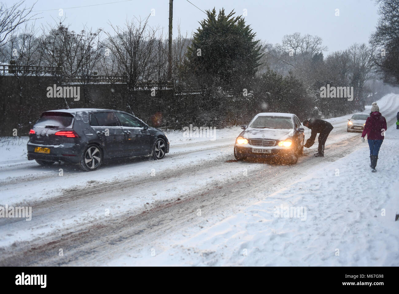 Southampton, Großbritannien. 1. März, 2018. Donnerstag, 1. März 2018 UKsnow West Wellow Southampton, England. Gemeinschaft spirt, ein paar Freunde, die in der Nähe der A36 live Gießen grit auf der Straße und hilft gestrandeten push Autofahrer auf einem der vielen Hügel entlang der Route in Richtung Southampton Rubrik von Salisbury. Sturm Emma kombiniert mit dem "Tier aus dem Osten' hits West Wellow, Romsey Hampshire am späten Nachmittag verursacht Chaos auf der A36 die Hauptroute von Southampton nach Salisbury. Autos und Lastwagen auf die vielen Hügel blockiert Verkehr stecken geblieben. Credit: PBWPIX/Alamy leben Nachrichten Stockfoto