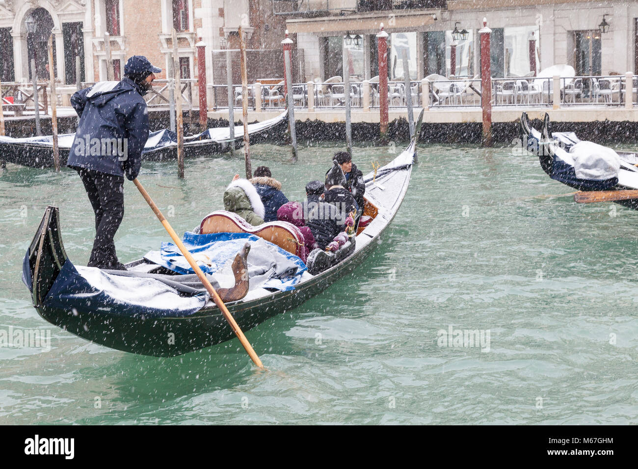 Venedig, Venetien, Italien, 1. März 2018. Schlechtes Wetter in Venedig heute mit Sub-zero temperatues zwischen minus 3 und minus 2 und kontinuierliche Schnee den ganzen Tag durch das Tier aus dem Osten, oder die Sibirische Front aus Russland quer durch Europa verursacht. Touristen im Schnee Gondeln gerudert wird von Gondolieri auf der Lagune oder Basino San Marco, auf der Piazza San Marco. Stockfoto