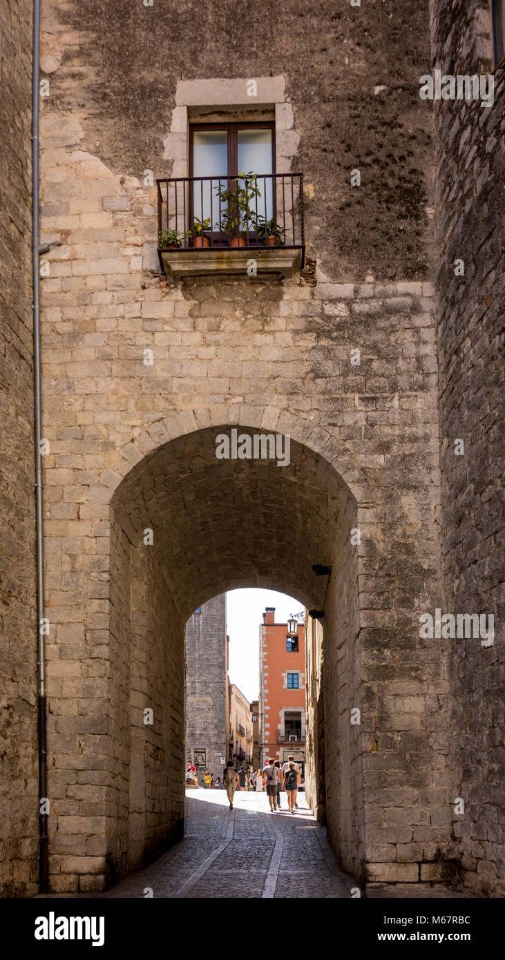 Touristen zu Fuß durch Passage der mittelalterlichen Mauer, Carrer de La Força, Girona, Katalonien, Spanien Stockfoto