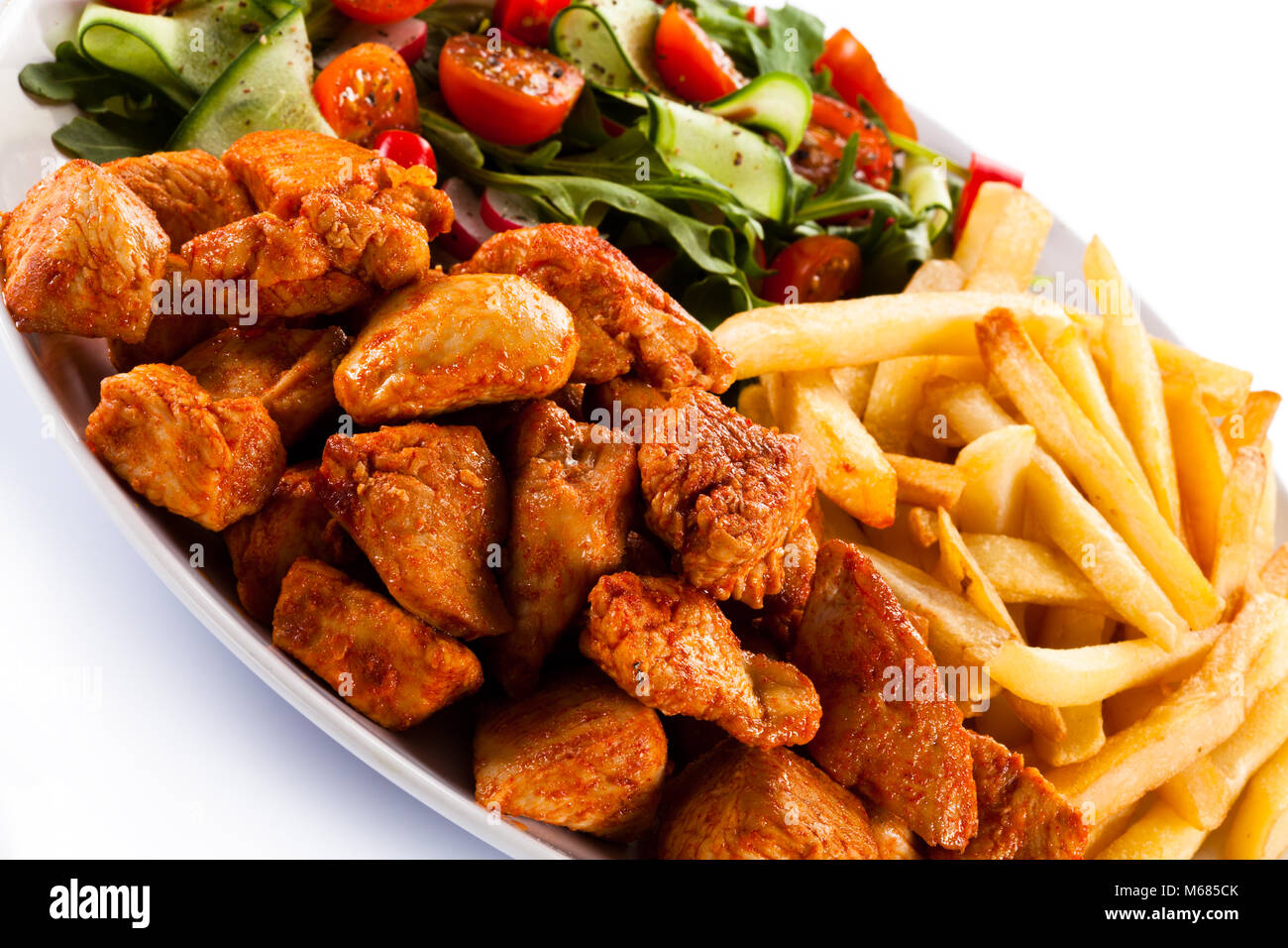 Fleisch vom Grill mit Pommes frites und Gemüse auf weißem Hintergrund  Stockfotografie - Alamy