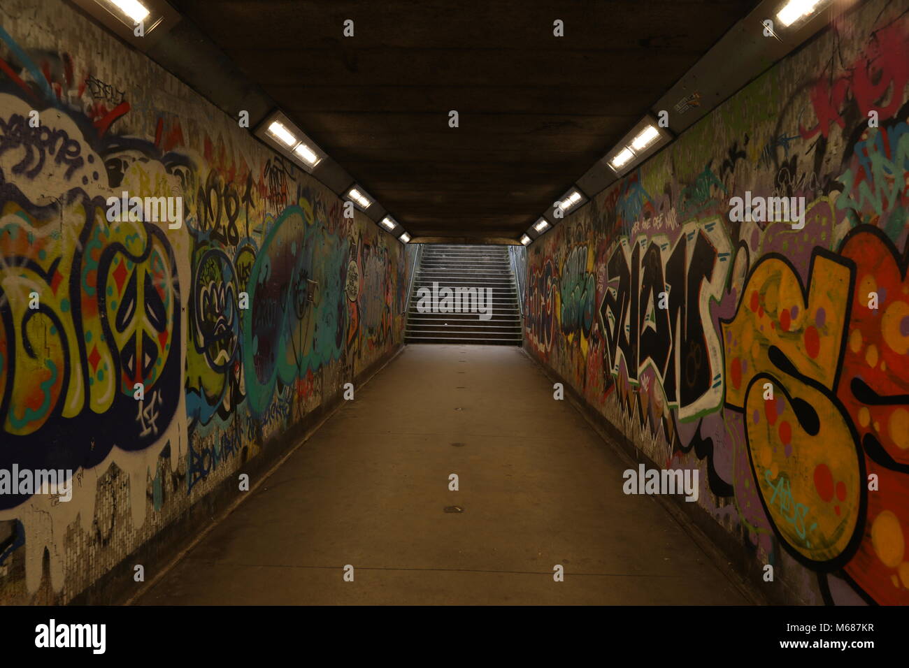 Licht am Ende des Tunnels, dunkle U-Bahn Tunnel mit Graffiti und Schritte Stockfoto