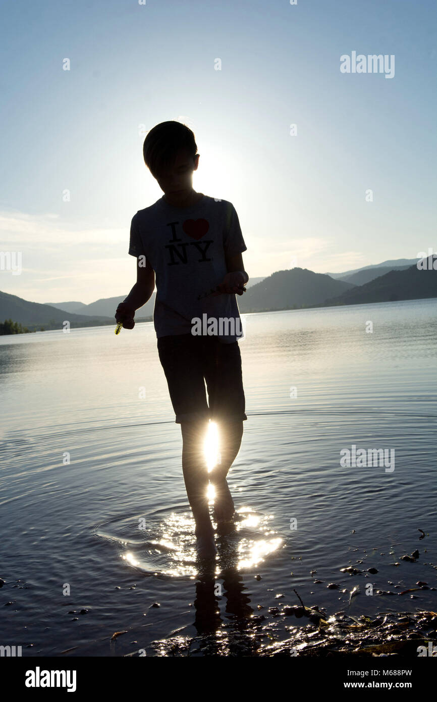 Hintergrundbeleuchtung Schuß eines Jugendlichen von hinten zu Fuß in den aufgestauten See Lac du Salagou angesehen (Südfrankreich) Stockfoto