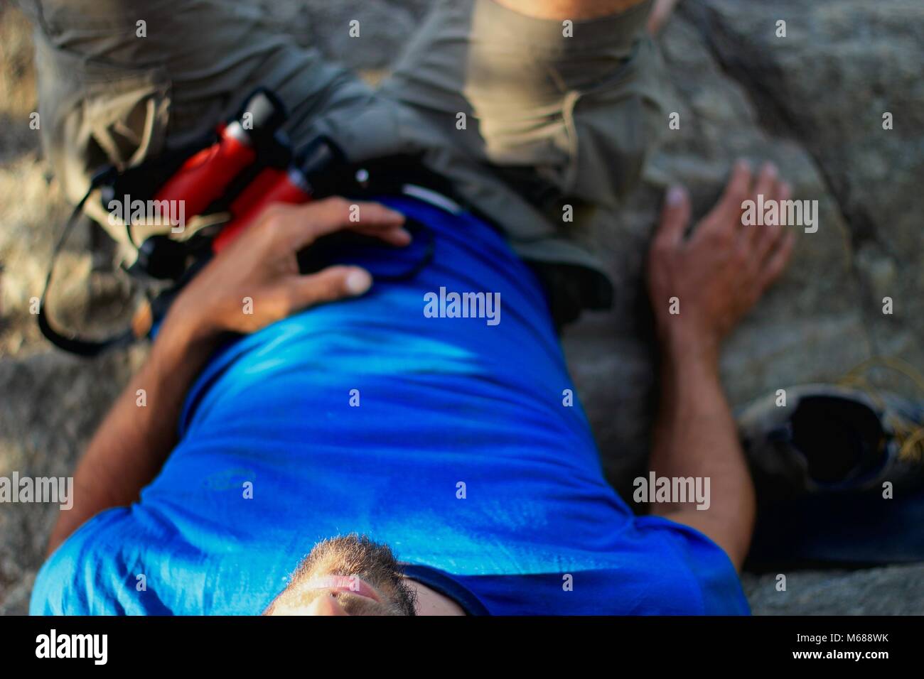 Die Hälfte der Körper eines Mannes, Verlegung auf einem Felsen, Fernglas Festlegung auf ihn Stockfoto