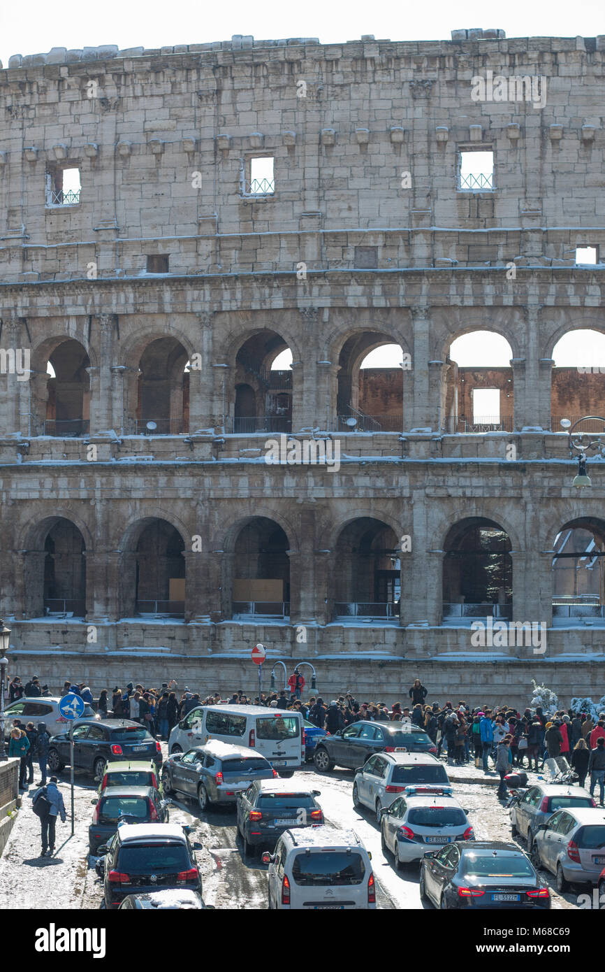 Menschenmassen und der Straßenverkehr in Rom vor dem Kolosseum im Schnee. Stockfoto